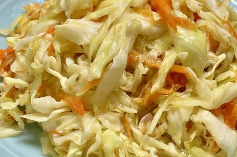 Bowl of fresh vinegar and oil coleslaw topped with herbs