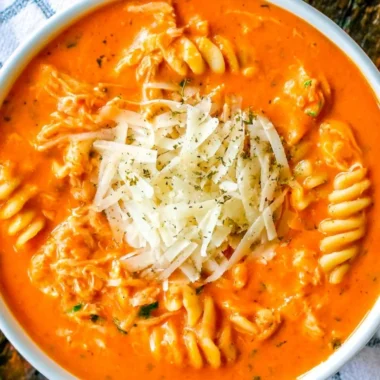 Bowl of Crockpot Chicken Parmesan Soup with cheese and herbs