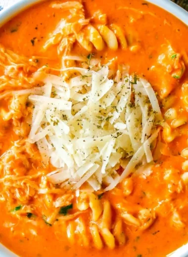 Bowl of Crockpot Chicken Parmesan Soup with cheese and herbs