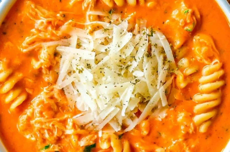Bowl of Crockpot Chicken Parmesan Soup with cheese and herbs